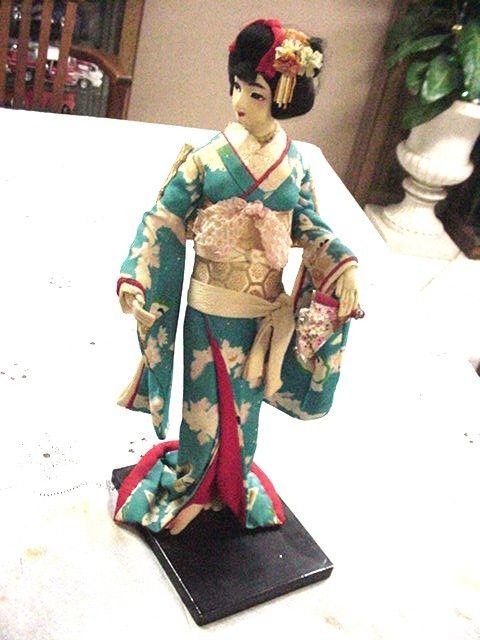 2 CLOTH GEISHA DOLLS WITH SILK KIMONOS ON WOODEN STAND, ONE BLUE ONE PALE YELLOW