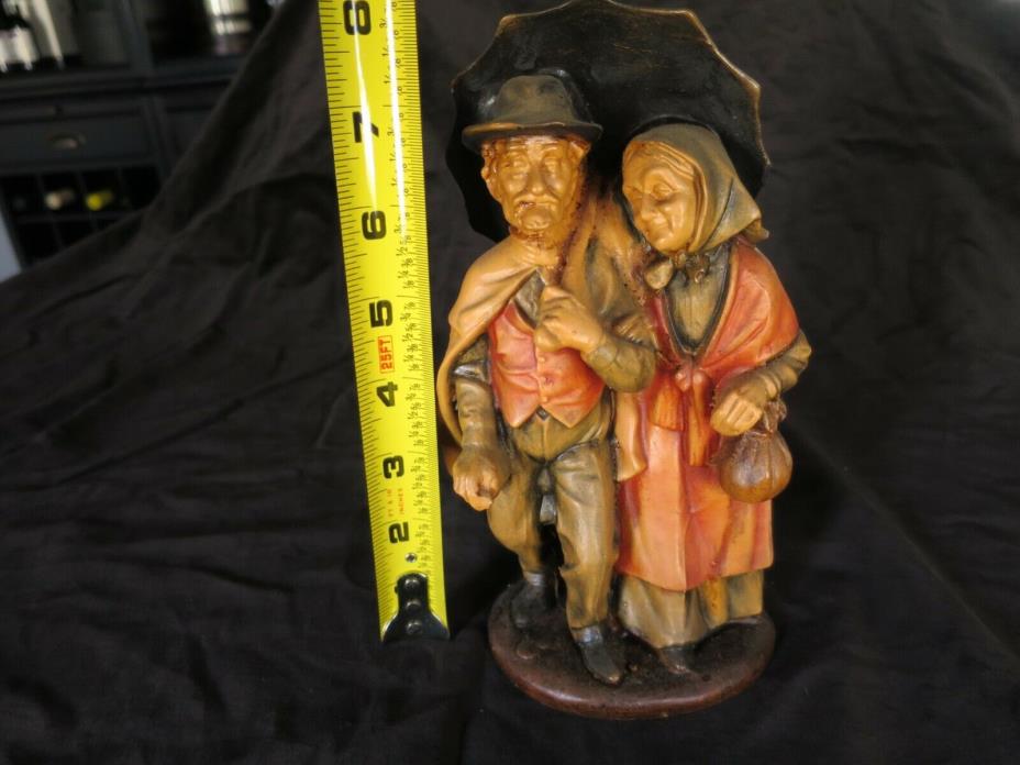 ELDERLY COUPLE FIGURINE UNDER UMBRELLA