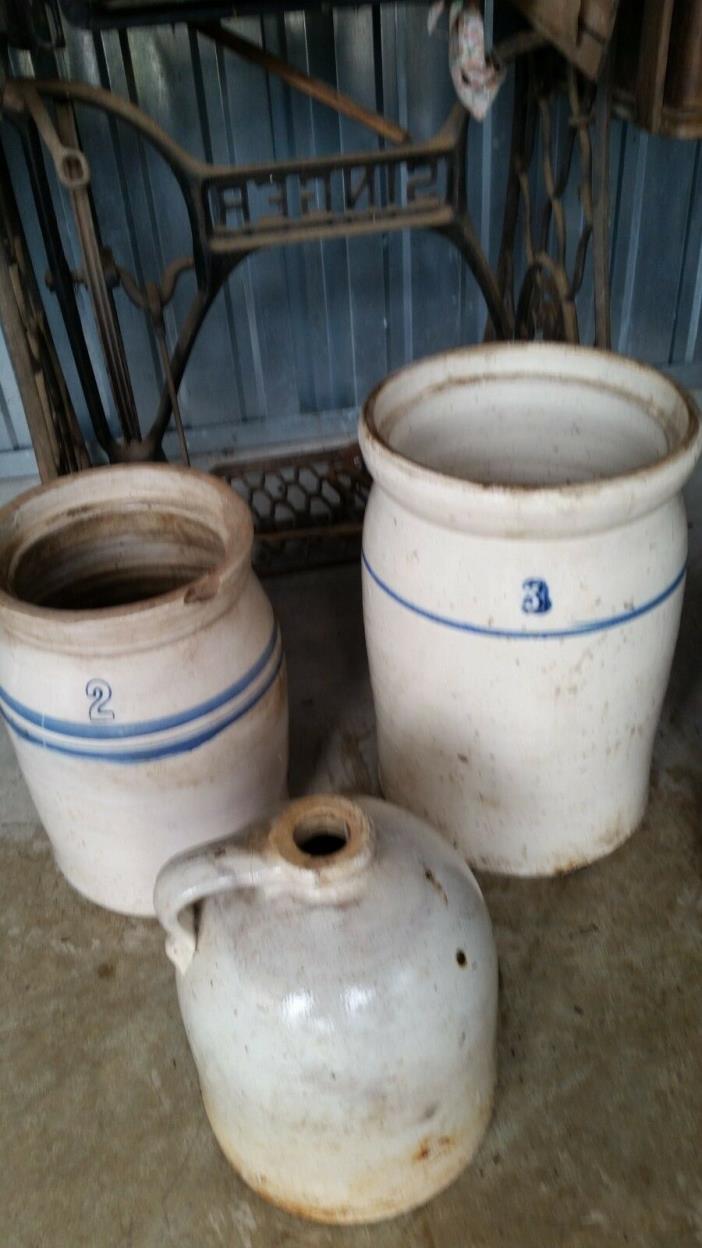 2 antique butter churns and a whiskey jug