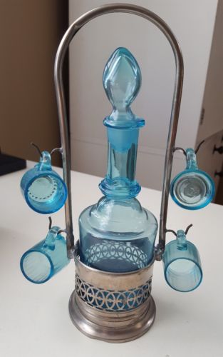 Antique aqua blue glass decanter, tiny cups set on silver caddy