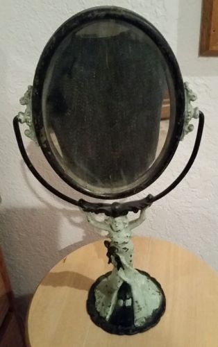 Vintage metal woman holding a mirror, vanity