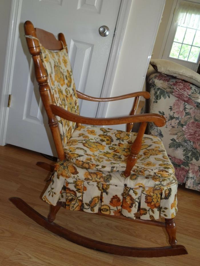 Antique wooden rocking chair, medium wood color, orange and brown cushions