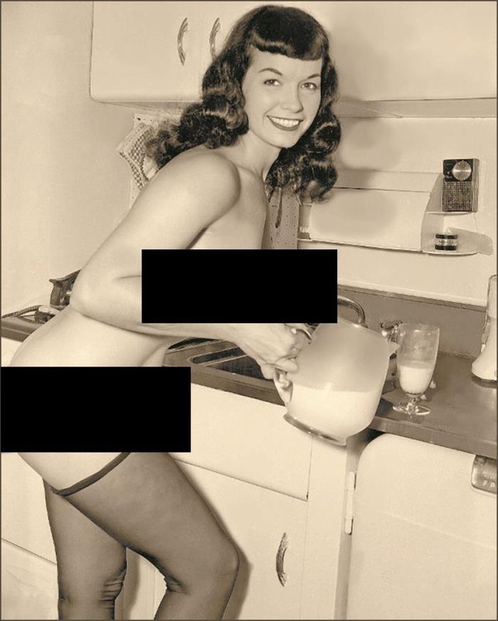 Bettie Page in kitchen pouring a glass of milk-Photo