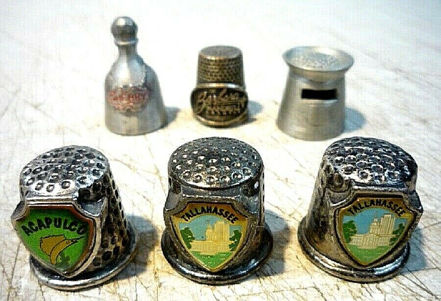 Six vintage metal pewter thimbles with different designs and destinations.