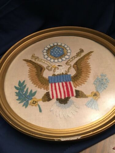 embroidered eagle picture on linen.  Round frame painted gold.  Chipped edge