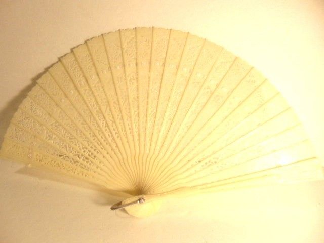 older ivory colored plastic hand fan - made in Hong Kong