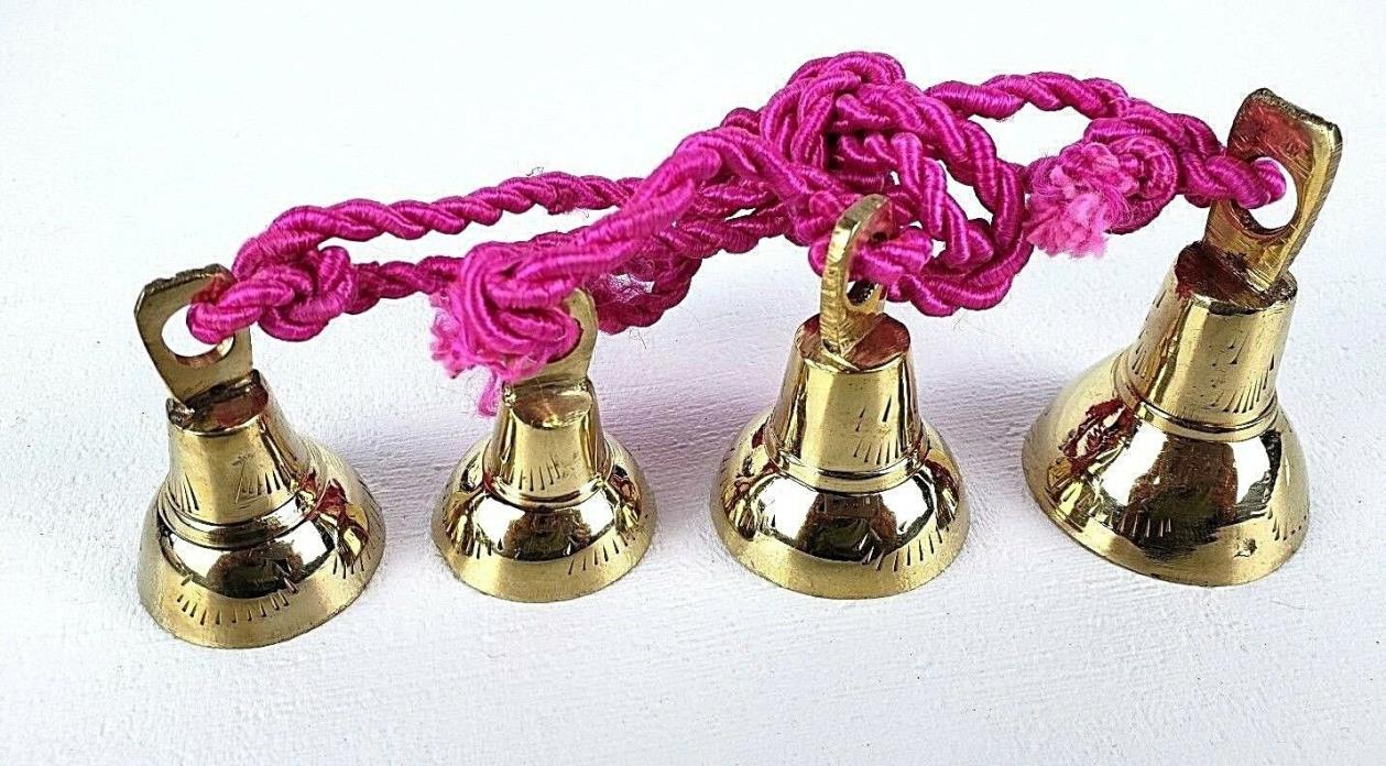 4 Brassy Bells Strung on a Pink Rope India Same Shape Different Sizes