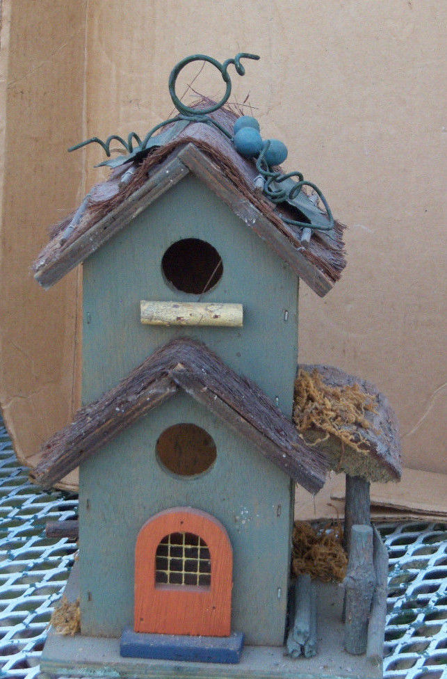Wooden condo birdhouse decorated with metal leaves and a metal hanger