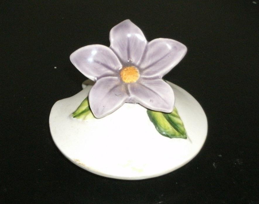 Lid with a spoon slot measuring two and one half inch round with a two inch roun
