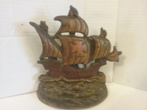 A CAST METAL SHIP ON THE WATER DOORSTOP