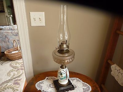 ANTIQUE KEROSENE OIL LAMP WITH PAINTED DUCK IN FOREST