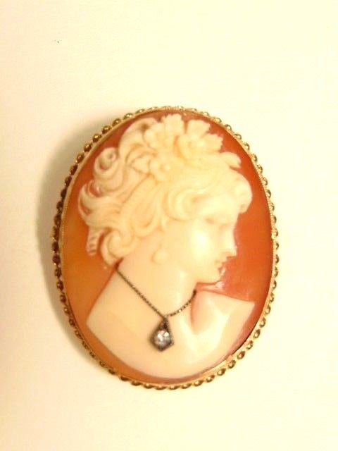 Older carved cameo set in 10K gold:  woman wearing a small diamond on necklace
