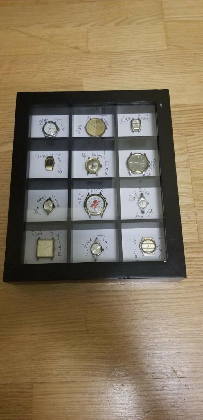 Group of 12 vintage watches in a display case