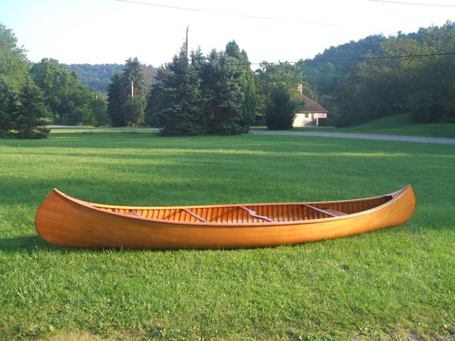 Handcrafted 17' Cedar rib wooden canoe with hand woven seats and brass trim