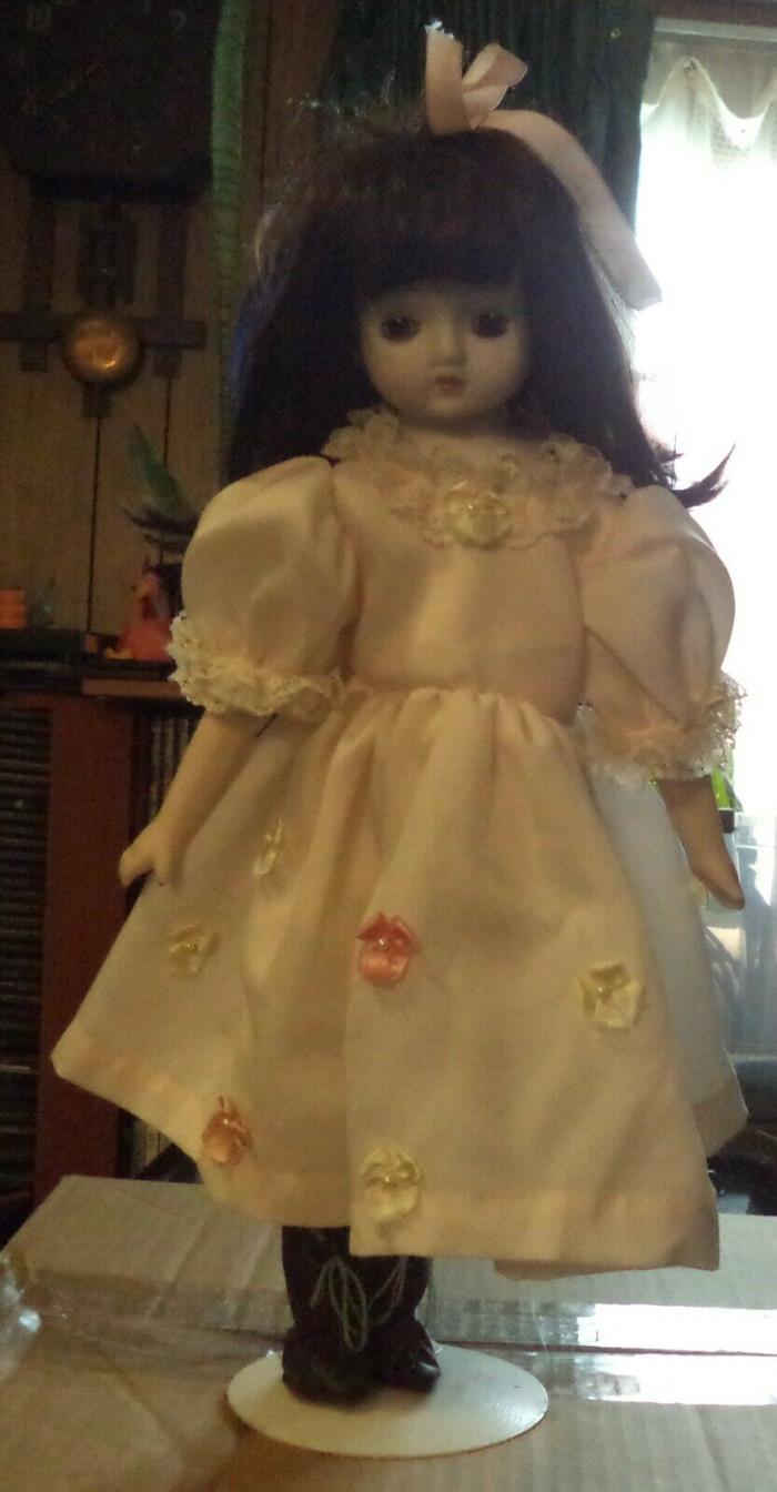Vintage porcelain doll with white dress and doll stand