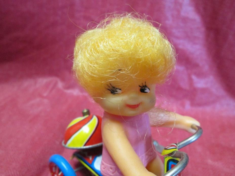 VINTAGE  METAL TOY    WIND- UP DOLL ON A TRICYCLE