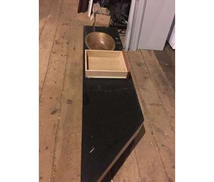 Black granite counter top with a copper sink and drawer